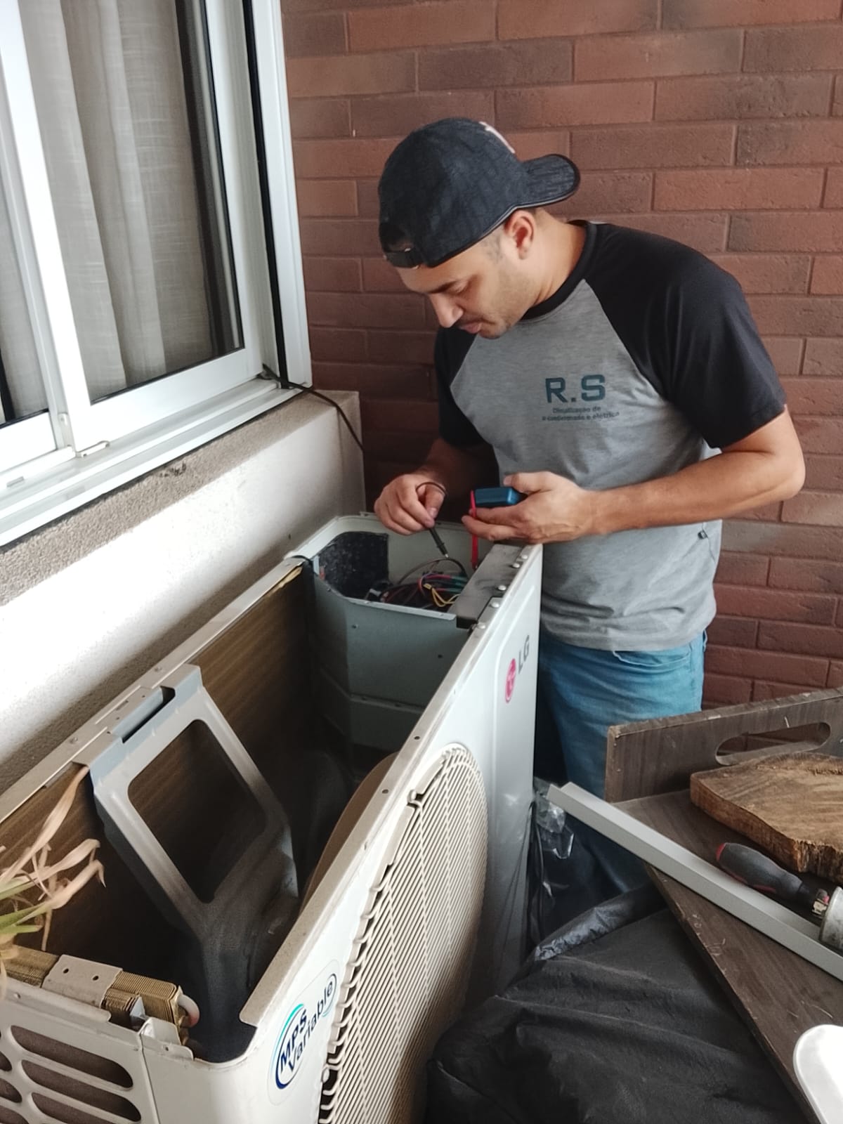 Técnico da RS Climatização trabalhando em uma condensadora de ar-condicionado
