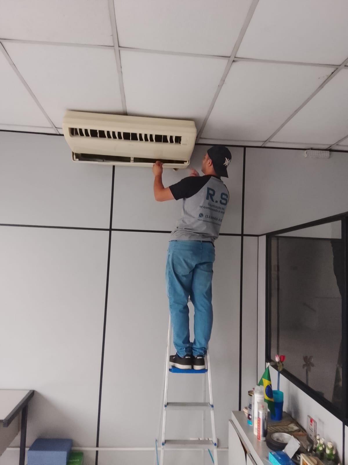 Técnico da RS Climatização instalando ar-condicionado em escritório